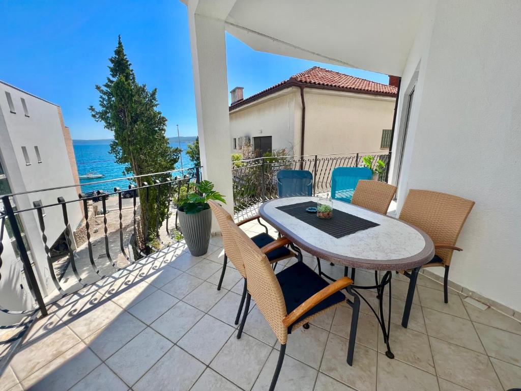 een balkon met een tafel en stoelen en de oceaan bij Apartman Salty Kisses in Crikvenica