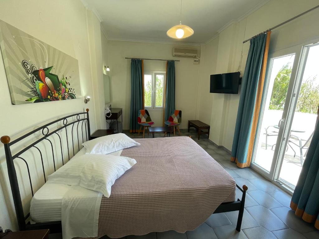 a bedroom with a bed and a large window at Albatros Hotel in Karterados