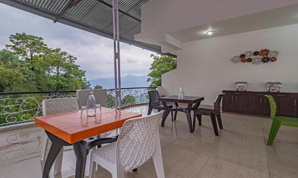uma sala de jantar com uma mesa e cadeiras numa varanda em Itsy By Treebo - Peak View, 300 Mts From Mall Road em Mussoorie