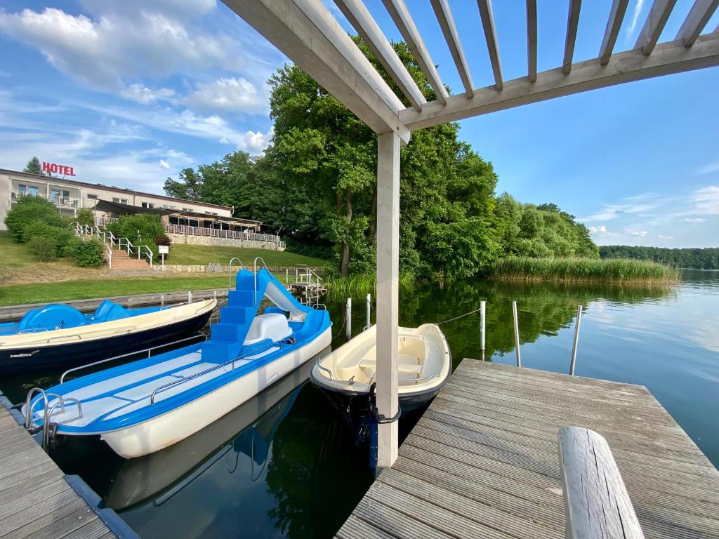 ein Boot an einem Dock auf dem Wasser angedockt ist in der Unterkunft Hotel am Untersee in Bantikow