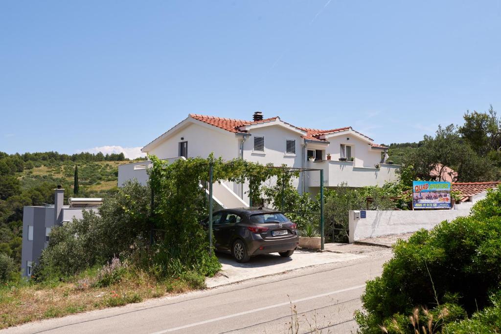 a car parked in front of a house on a street at Guesthouse Aria in Trogir