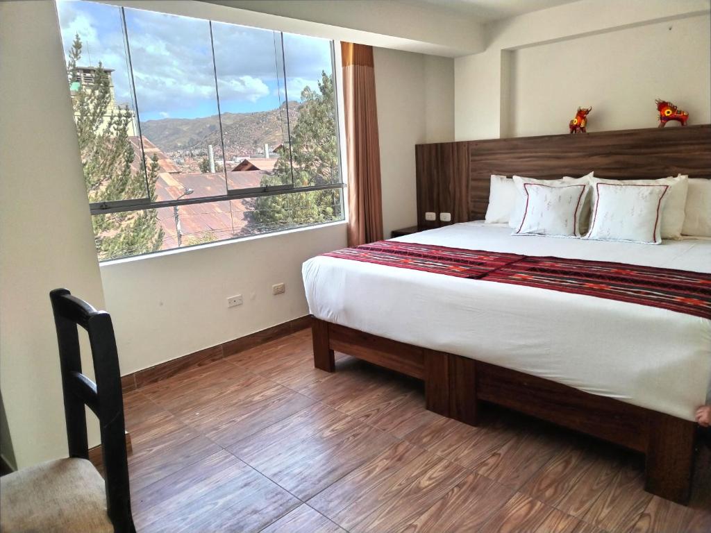 a bedroom with a large bed with a large window at Dreams Boutique Hotel Cusco in Cusco
