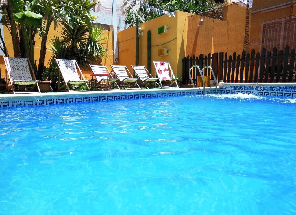 a large swimming pool with chairs at Casa Rural Jardín del Desierto in Tabernas