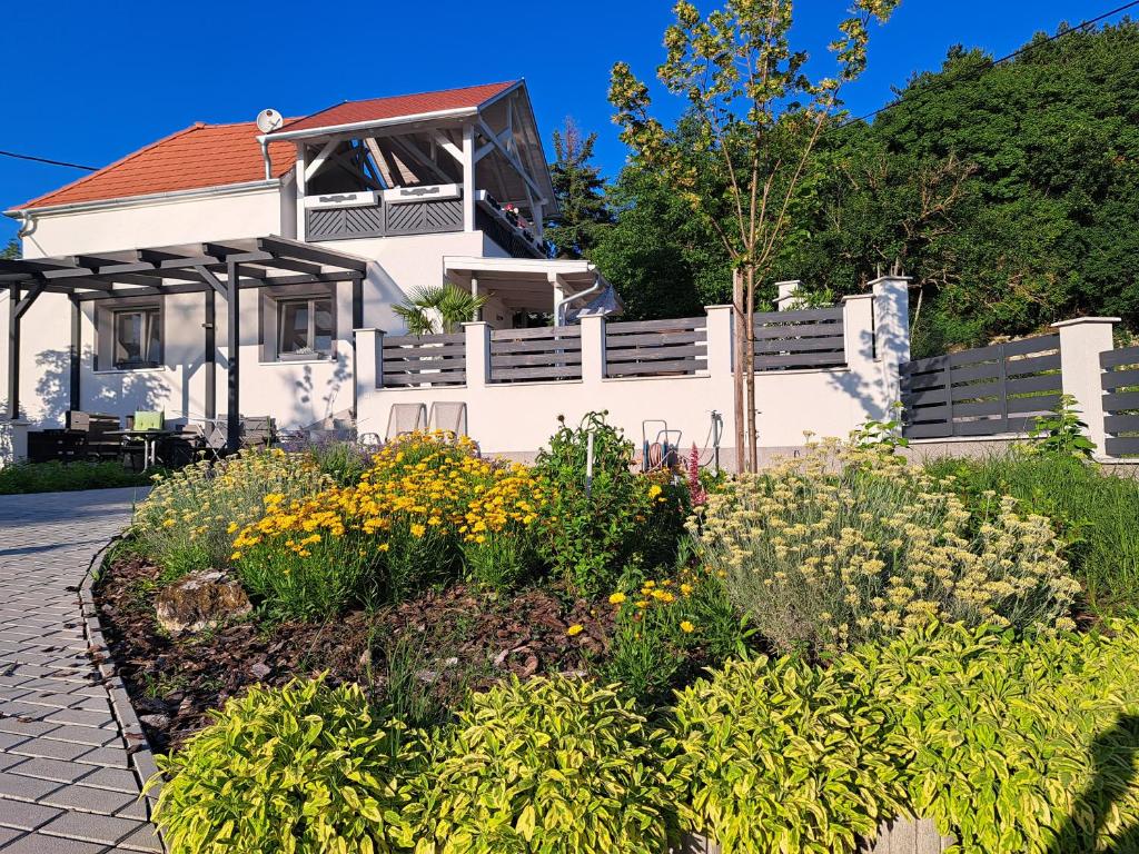 un jardín frente a una casa blanca en Apartman for You en Gyenesdiás