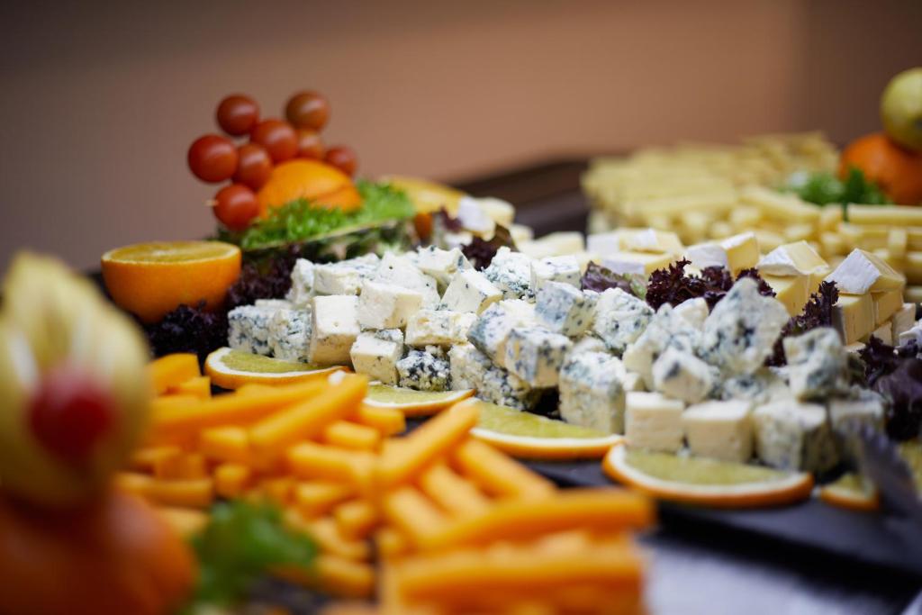 a table topped with plates of food with cheese and fruit at Sandos Benidorm Suites in Benidorm
