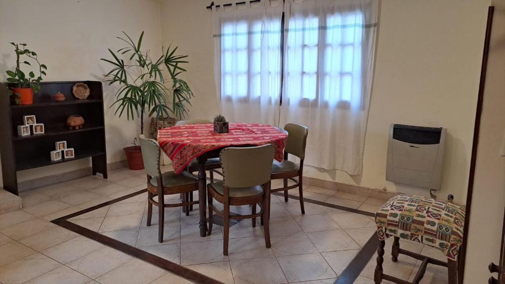 a dining room with a red table and chairs at LatorrePAS Dpto in Salta