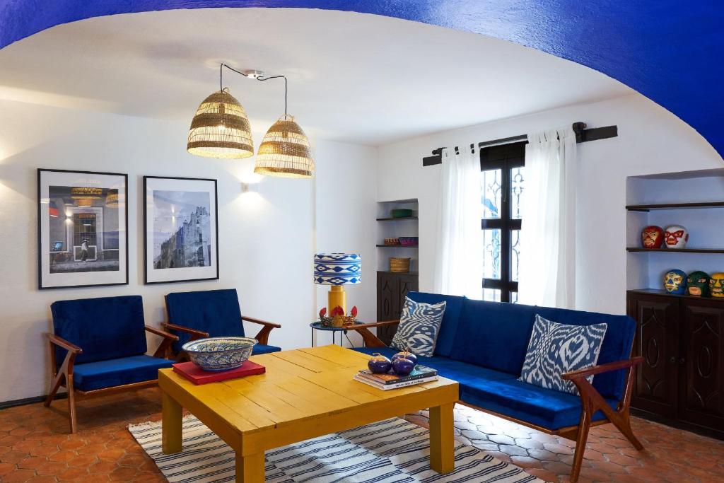 sala de estar con sofá azul y mesa de madera en AmazINN Places Casa Coyoacan en Ciudad de México
