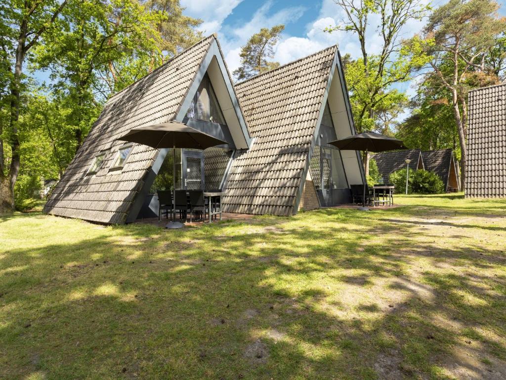 StramproyにあるSecluded Holiday Home in Limburg with a Terraceのガムブルルーフの家(椅子2脚、窓付)