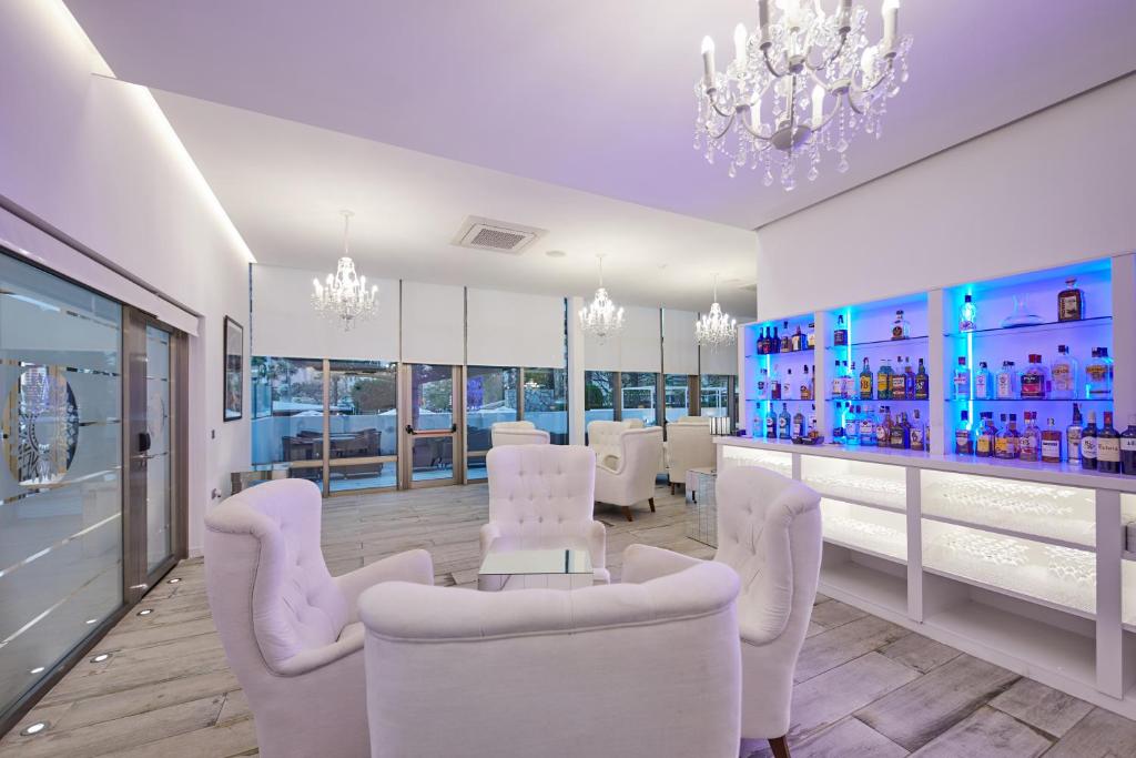 a salon with white chairs and a bar at Sandos Benidorm Suites in Benidorm