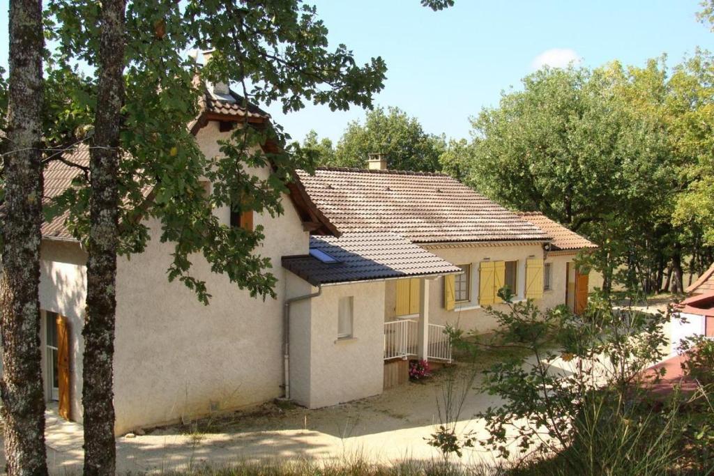 Une petite maison blanche avec volets jaunes dans l'établissement Chambre d'hôte La Blénie, à Gignac