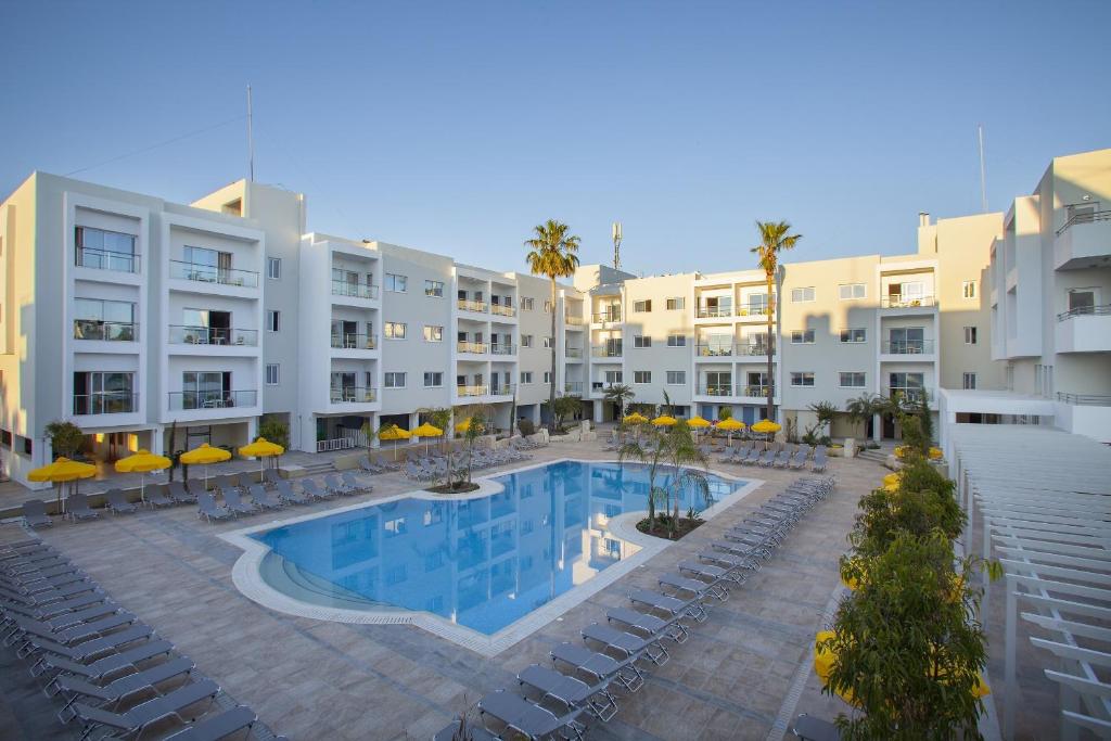 uma imagem do pátio de um hotel com piscina em Mayfair Hotel formerly Smartline Paphos em Pafos