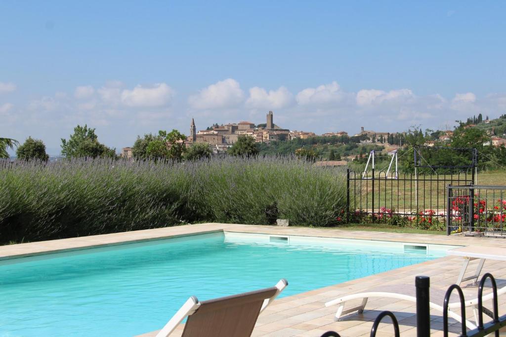 una piscina con 2 sillas de jardín junto a ella en Villa Castiglioni, en Castiglion Fiorentino