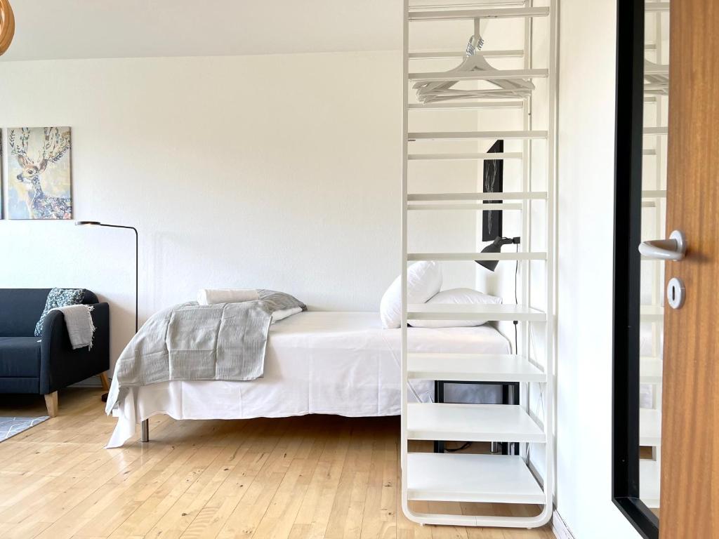 a bedroom with a ladder next to a bed at Studio Apartment In Glostrup, Hovedvejen 70, 3 in Glostrup