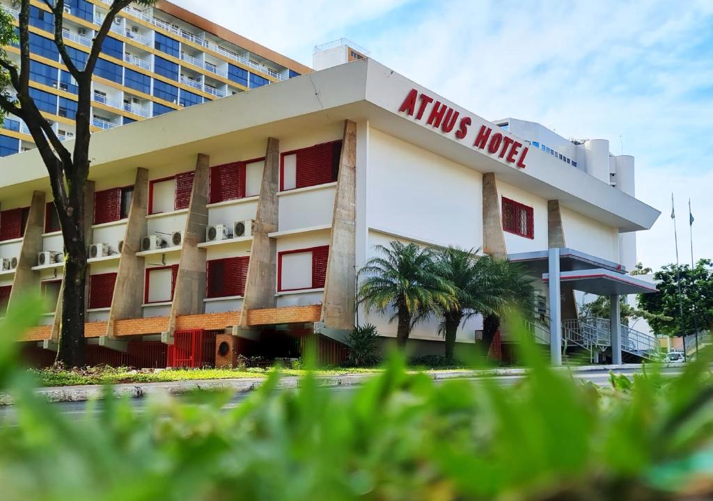 an atlas inn hotel with palm trees in front of it at Athus Brasilia Hotel - Antigo Aristus in Brasilia