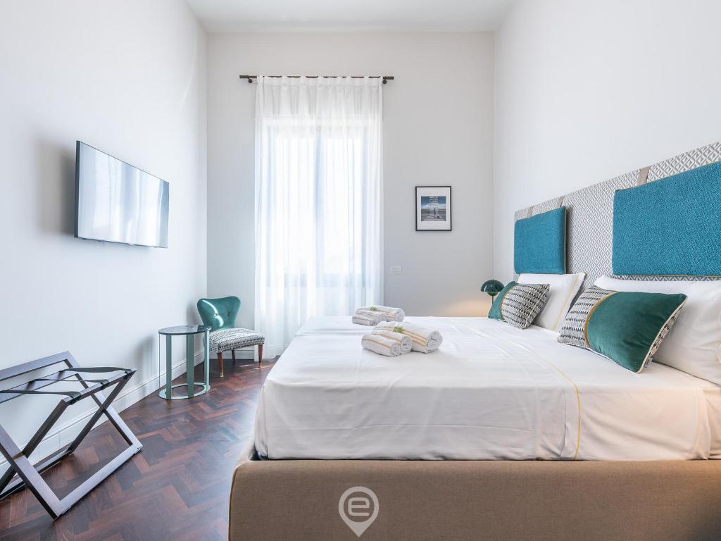 カリアリにあるVerso Suite Cagliari - Charm in the City Centreの白いベッドルーム(ベッド2台、テーブル付)