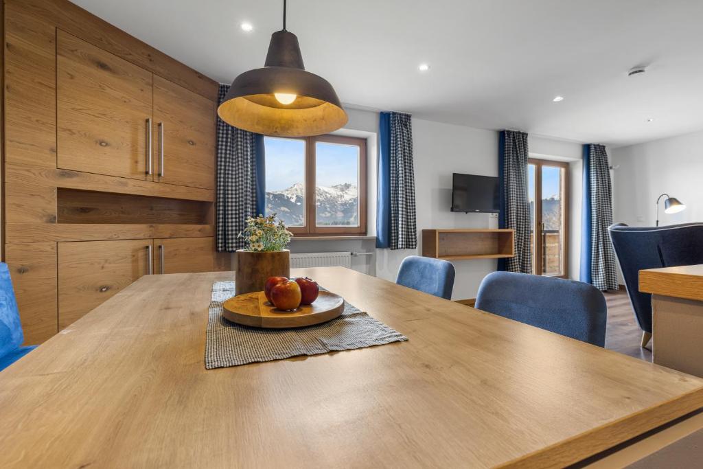 a kitchen and dining room with a wooden table at Berghaus Mucha - Ferienwohnungen in Bolsterlang