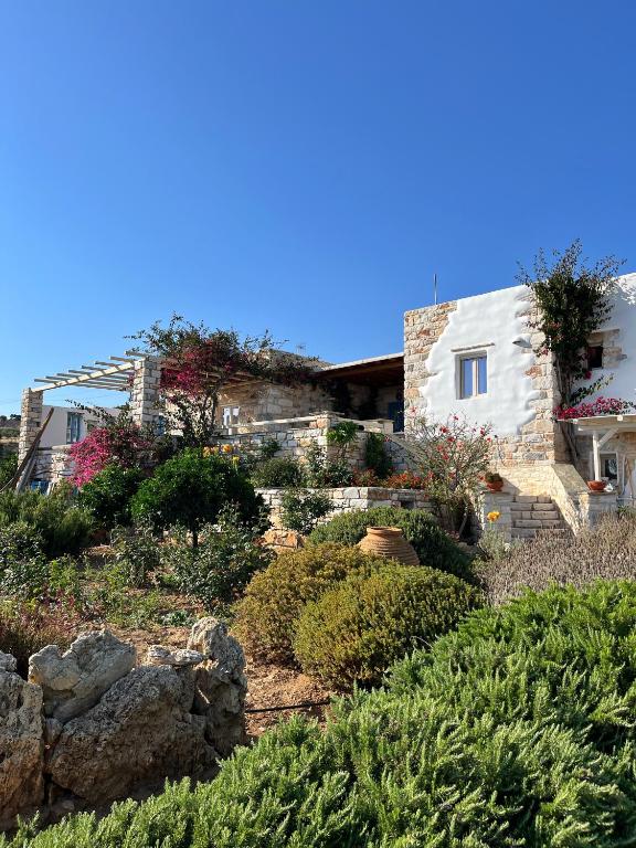 a house on a hill with flowers and plants at Stone Villa Mina in Angairiá