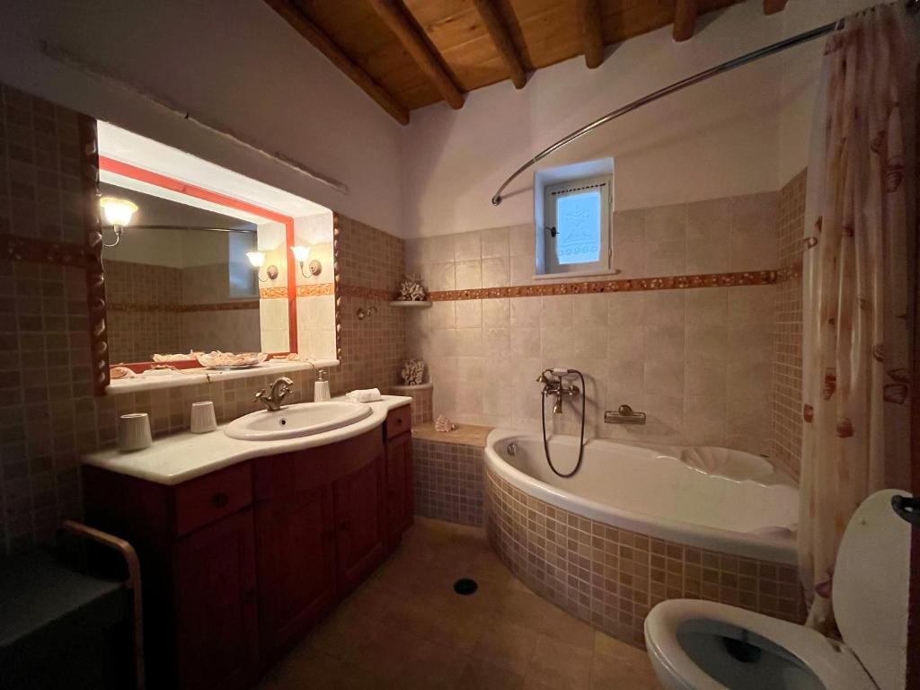 a bathroom with a tub and a sink and a bath tub at Stone Villa Mina in Angairiá