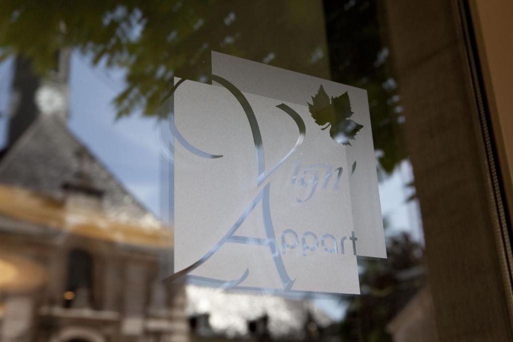 un cartel en una ventana con un edificio en el fondo en Vign 'Appart, en Nuits-Saint-Georges