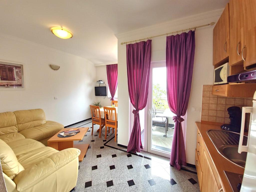 a living room with purple curtains and a couch at Apartment Tomić 3 Makarska in Makarska