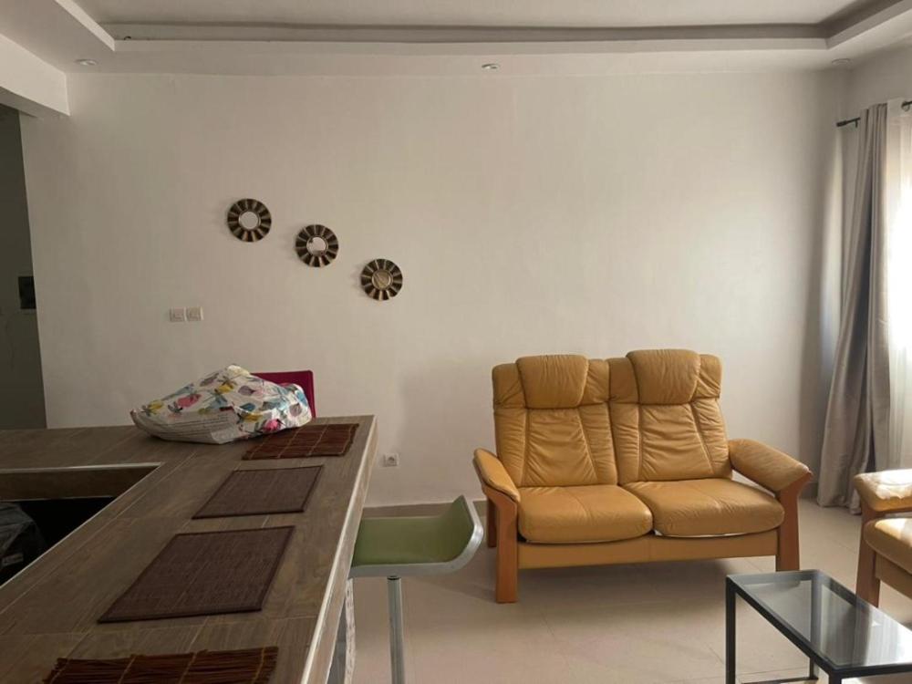 a living room with a couch and a table at CAB LFS SIPRES MOURTADA 3e ETAGE in Dakar