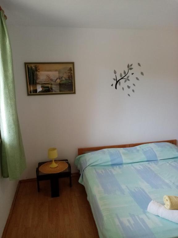 sypialnia z łóżkiem i stołem z obrazem na ścianie w obiekcie apartman Mirko w Puli