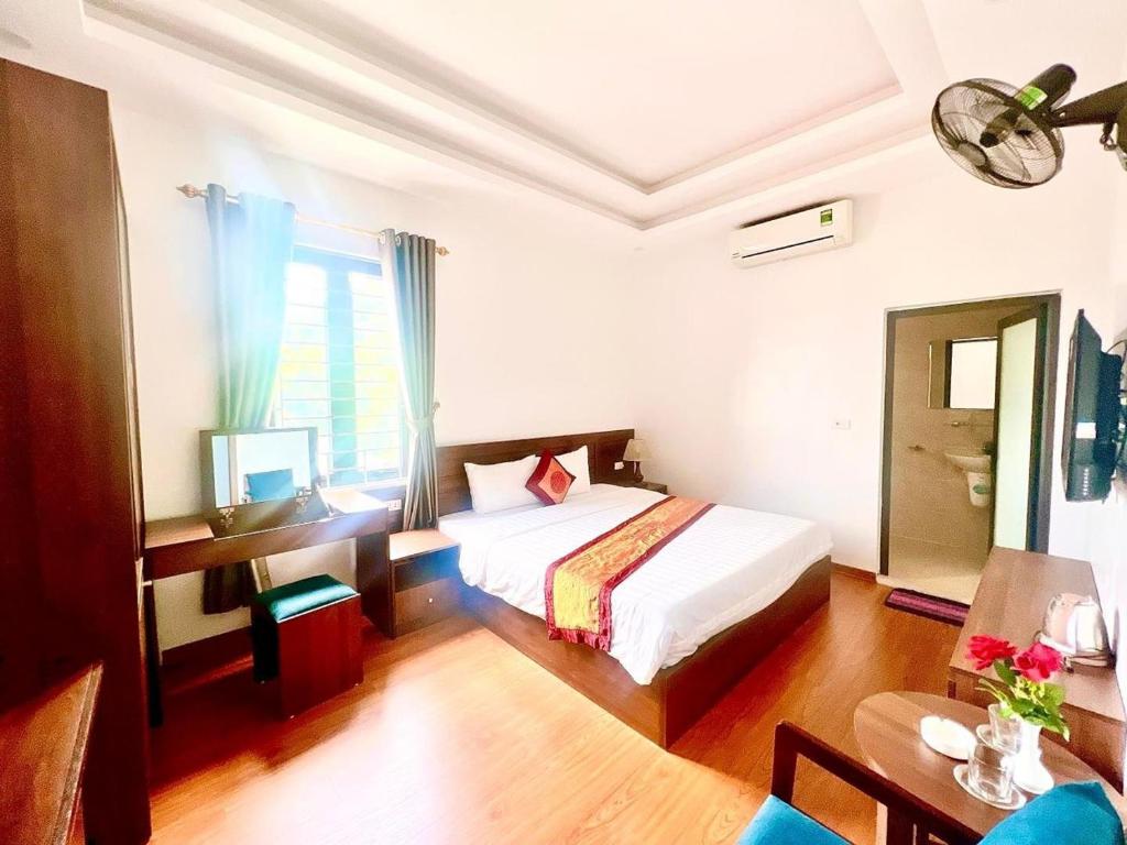 une chambre d'hôtel avec un lit, une table et une télévision dans l'établissement Khách sạn Lâm Viên, à Pho Mới