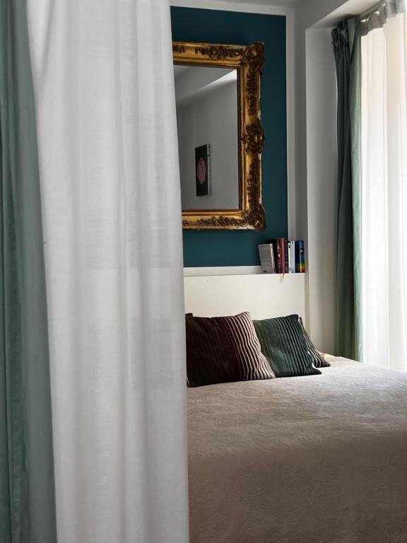 een slaapkamer met een bed en een spiegel bij Studio Olive in La Ciotat