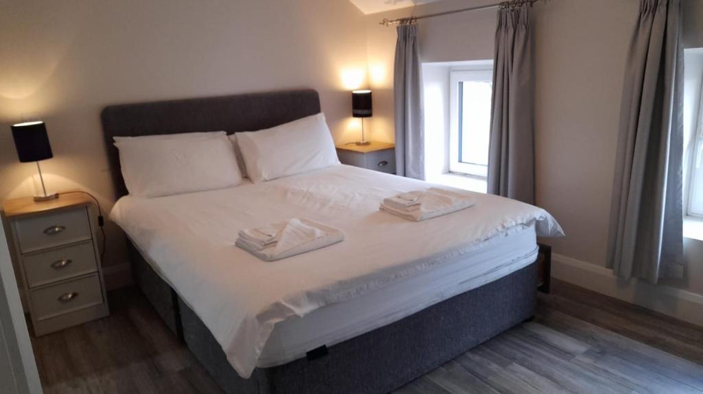 een slaapkamer met een bed met twee handdoeken erop bij The Helm Garden Terrace in Westport