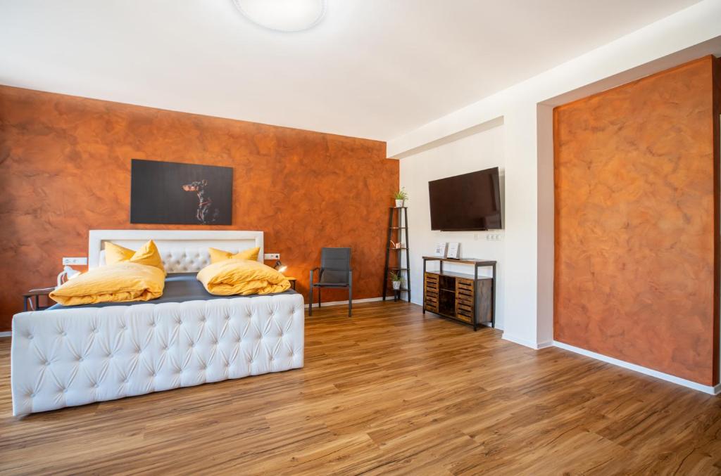 ein Schlafzimmer mit einem weißen Bett und gelben Kissen in der Unterkunft Gwuni Mopera in Leipzig