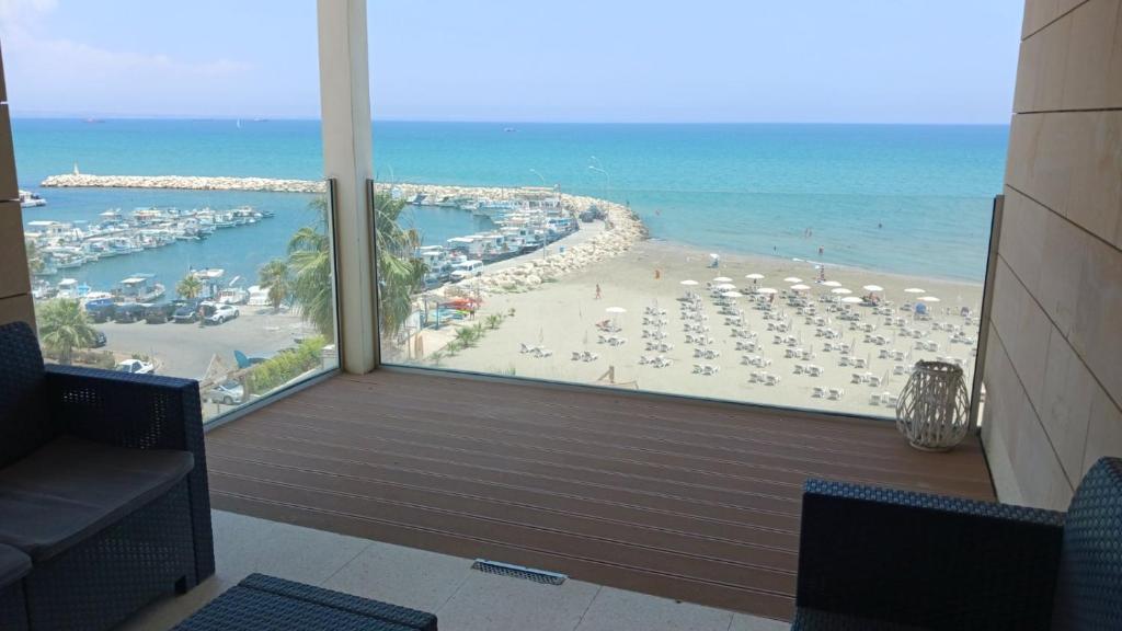 a room with a view of a beach and the ocean at Lazuli Sea View Beachfront Ap 254 in Larnaka