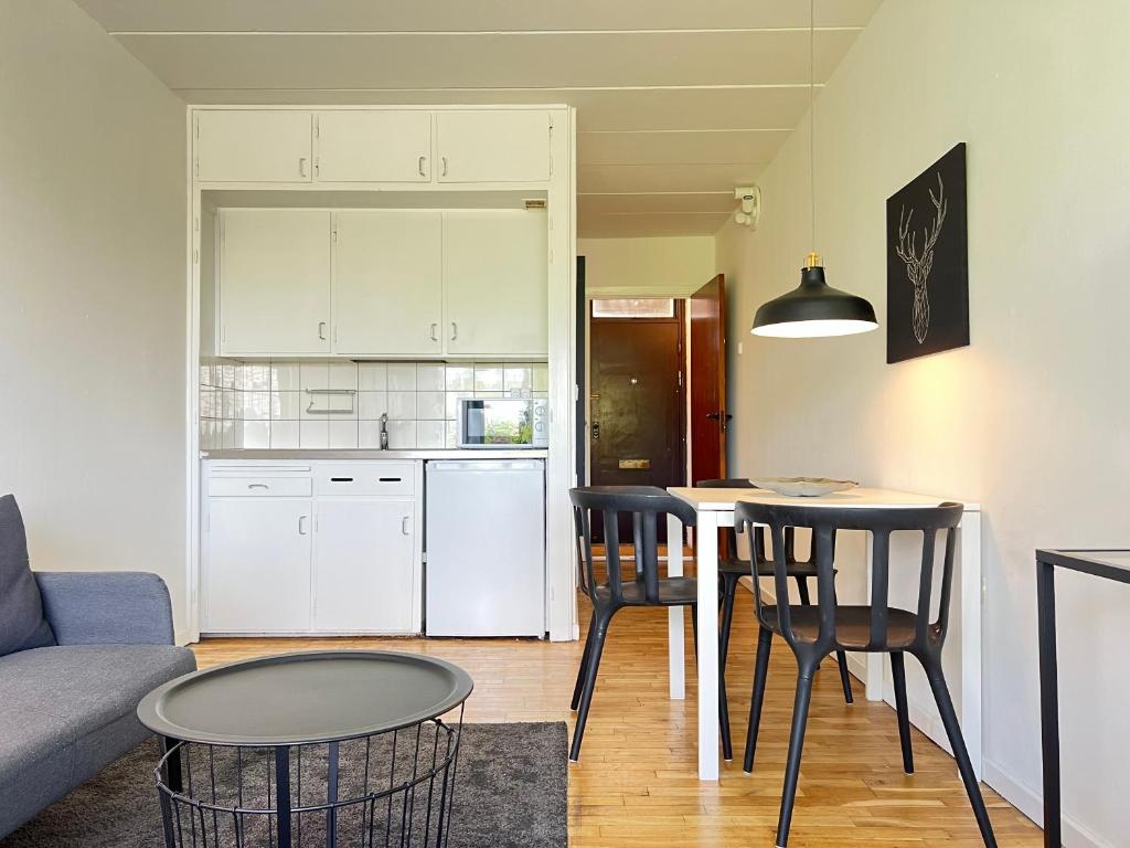 uma cozinha e uma sala de estar com mesa e cadeiras em Studio Apartment In Rdovre em Rødovre