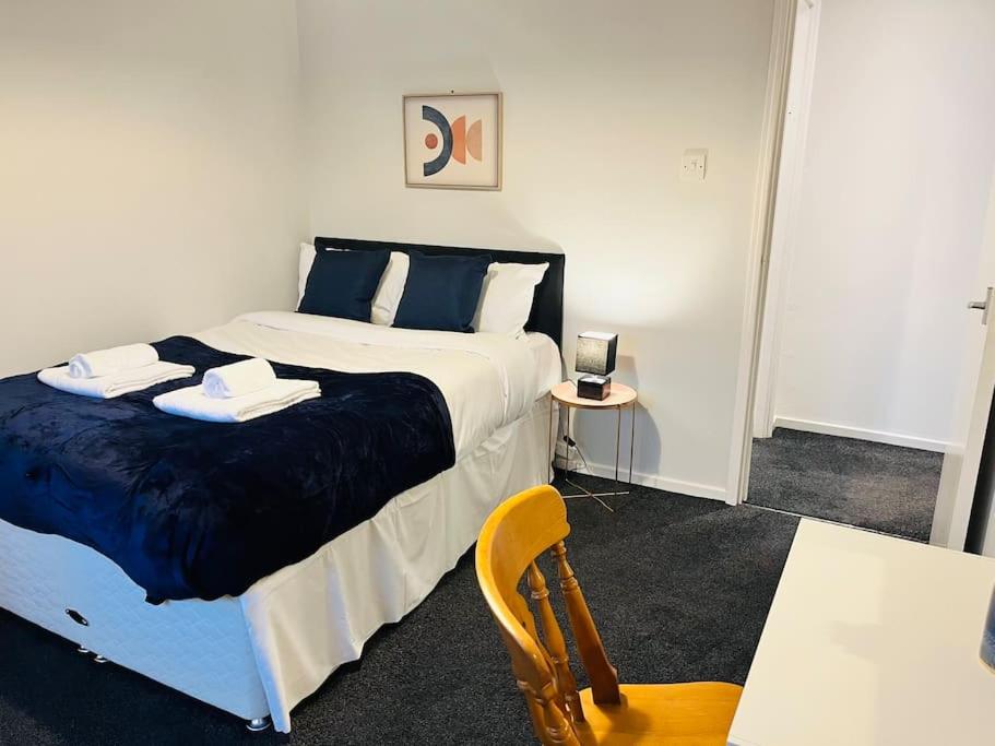1 dormitorio con 1 cama, 1 mesa y 1 silla en Family Home in Residential Neighbourhood en Cardiff