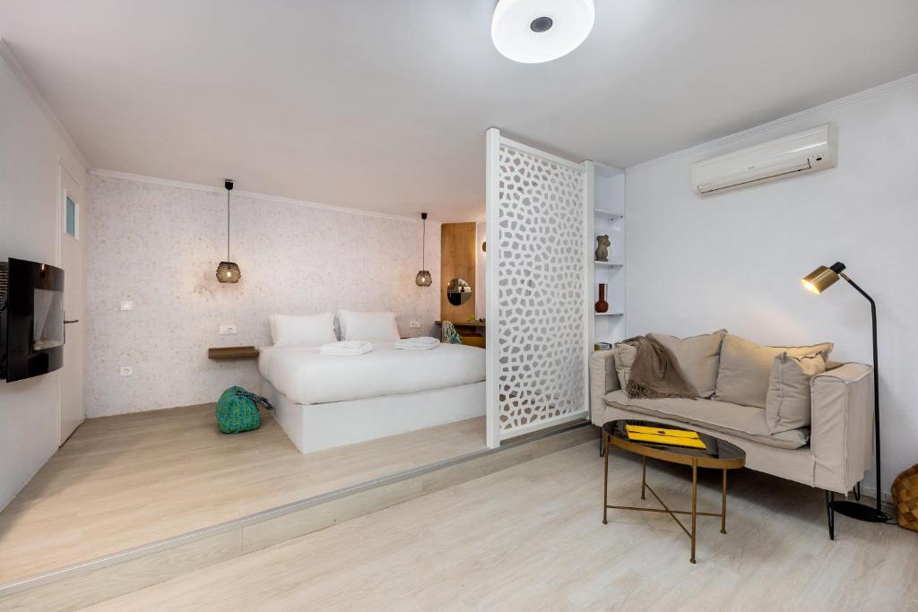 1 dormitorio con 1 cama y 1 sofá en una habitación en Seaside Nestie by BluPine, en Atenas