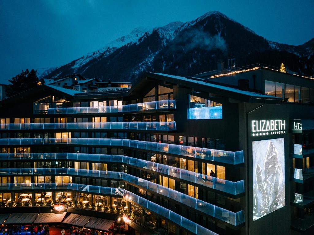 Außenansicht des Hotel Elisabeth in Ischgl mit Balkonen und traditioneller alpiner Architektur, umgeben von Schnee