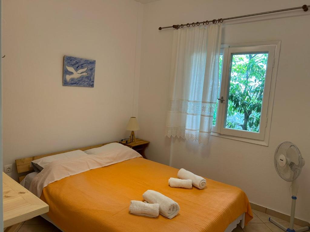 a bedroom with a bed with two towels on it at Orange Tree Garden in Pefkochori