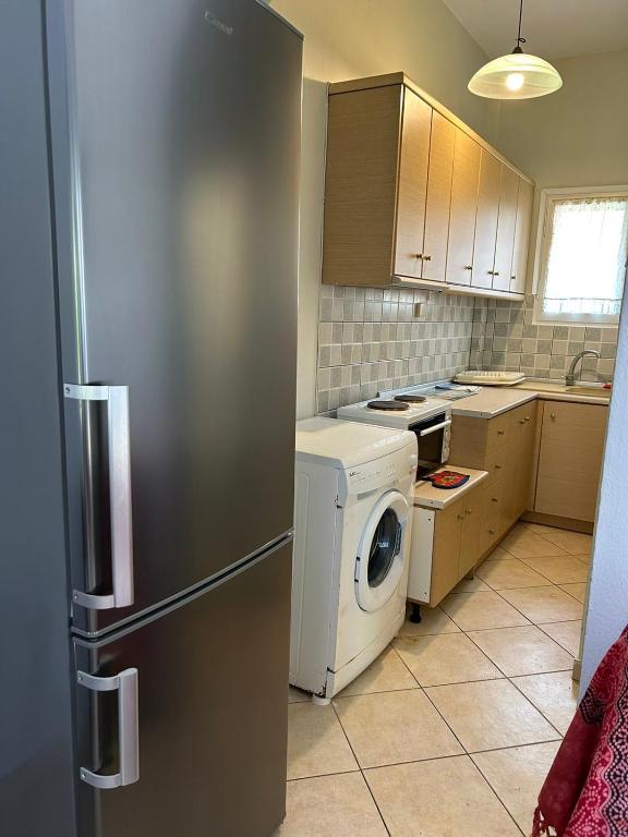 a kitchen with a refrigerator and a washing machine at Orange Tree Garden in Pefkochori