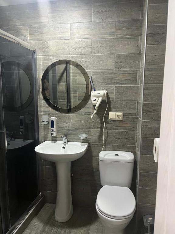 ein Badezimmer mit einem WC, einem Waschbecken und einem Spiegel in der Unterkunft Cozy Rooms in Kobuleti