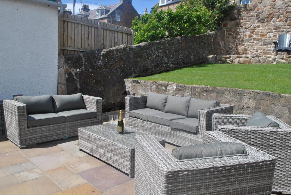 a group of wicker chairs and couches on a patio at Coastal Rest- superb East Neuk townhouse in Anstruther
