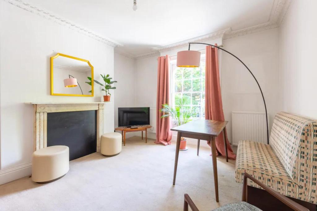 a living room with a table and a fireplace at Charming & Central 2BD Flat - Islington in London