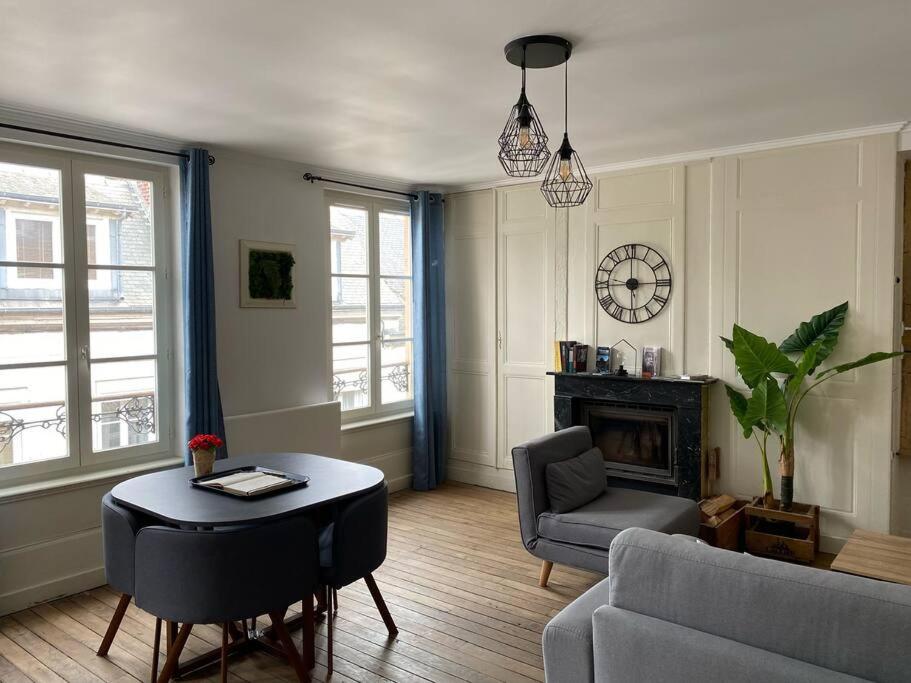 uma sala de estar com uma mesa e um sofá em Appartement de charme en hyper-centre em Charleville-Mézières