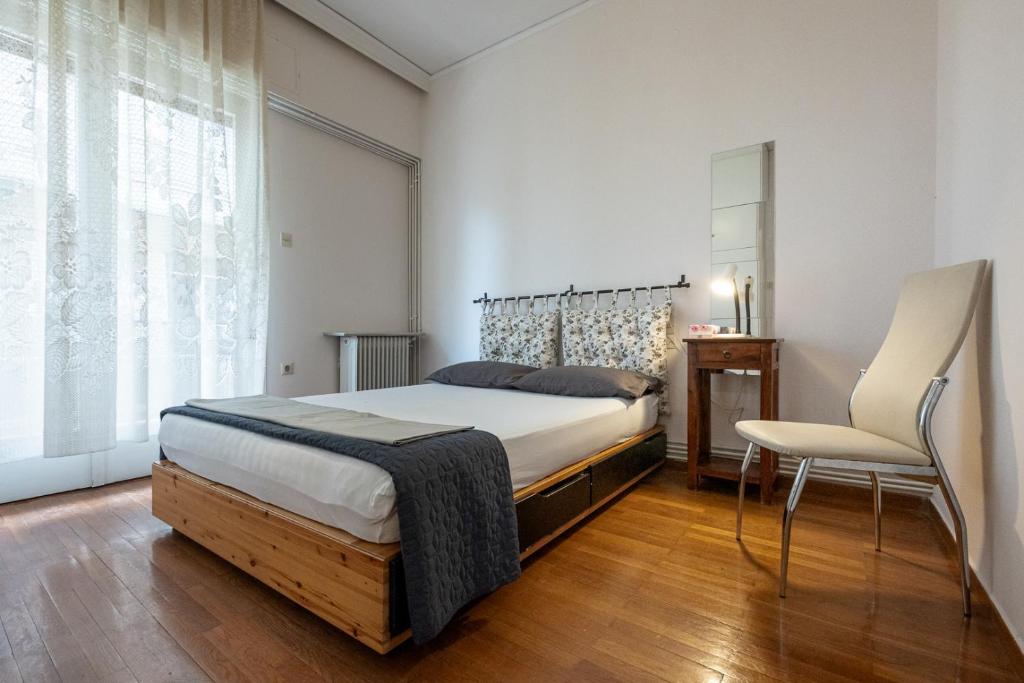 um quarto com uma cama e uma cadeira em Classy spacious central appartment em Volos