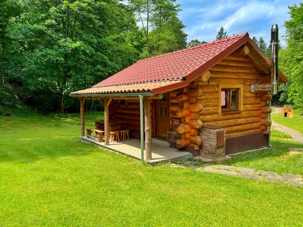 eine kleine Blockhütte mit rotem Dach in der Unterkunft Dům a Dům Živohošť in Živohošť
