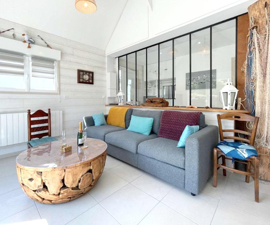 uma sala de estar com um sofá azul e uma mesa em Maison de 2 chambres avec jardin clos et wifi a Saint Laurent sur Mer em Saint-Laurent-sur-Mer