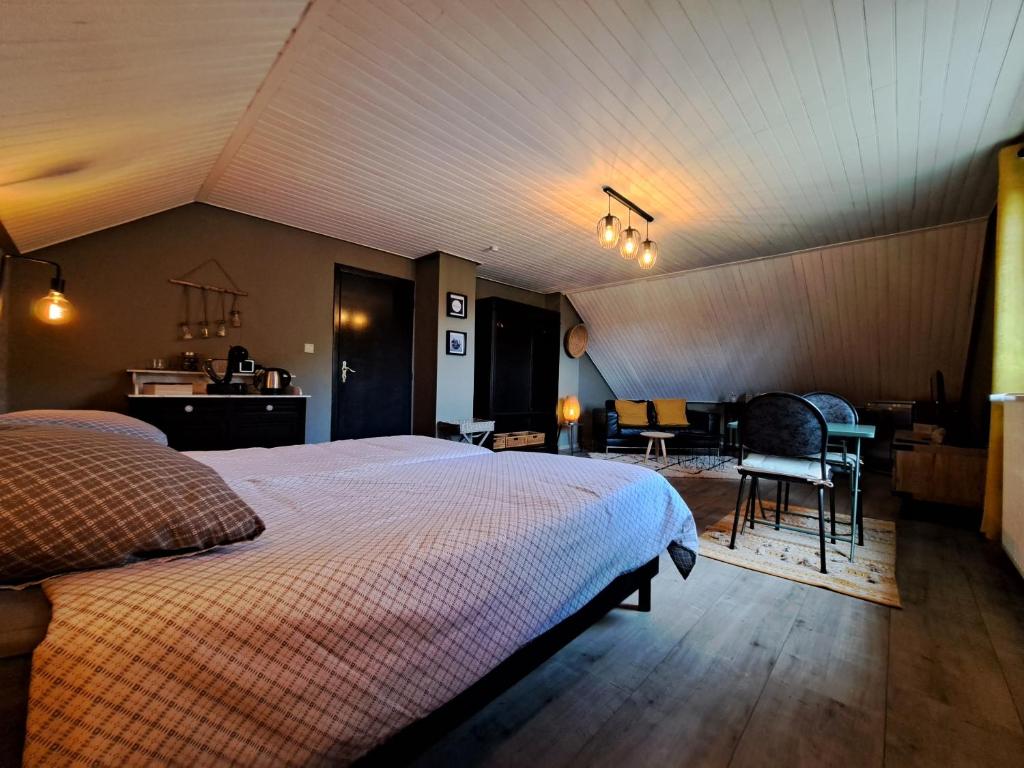 Chez Baf - Wibrin - Houffalize في Wibrin: غرفة نوم بسرير وطاولة وكراسي