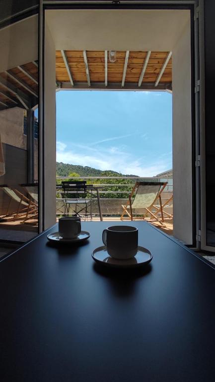 two cups sitting on a table in front of a window at Bohemia - T2 Design avec Terrasse proche de Cassis in Roquefort-la-Bédoule