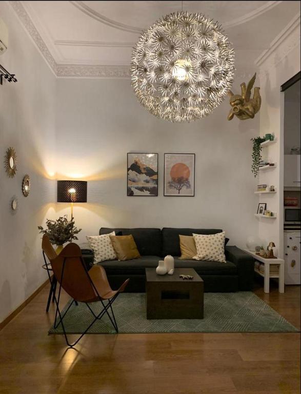 a living room with a couch and a chandelier at Eixample Apartment in Barcelona