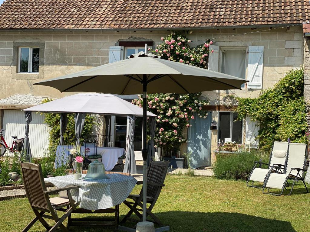 einen Tisch und Stühle mit Sonnenschirm im Hof in der Unterkunft Le Ronsard in Blye