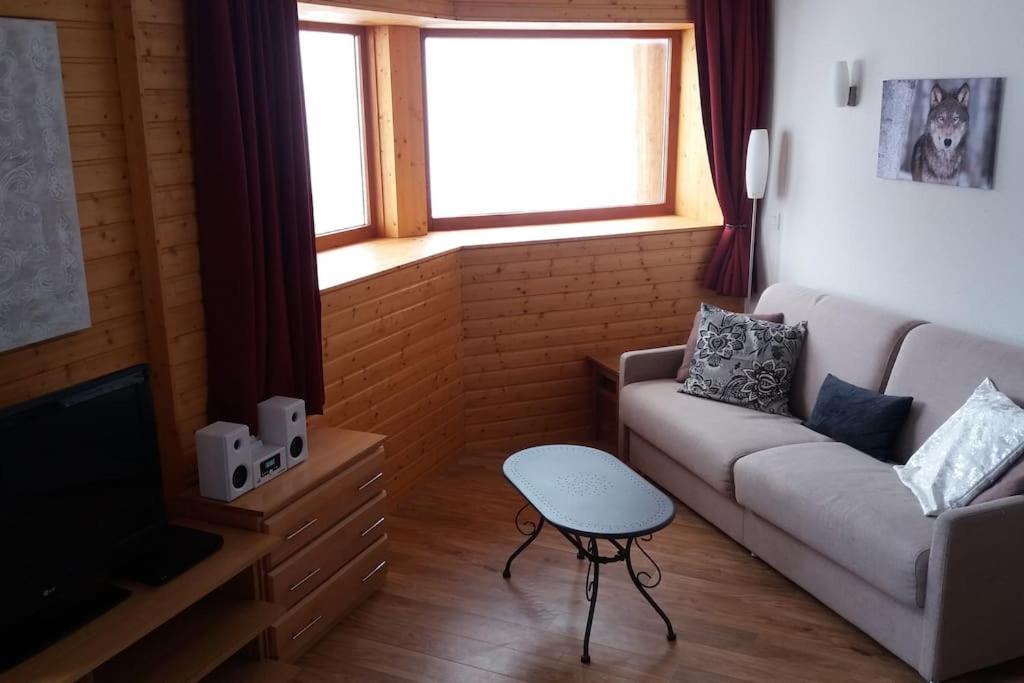 a living room with a couch and a television at CHAMROUSSE T2 Sud Ski Rando et Vtt aux pieds Les balcons du Recoin in Chamrousse