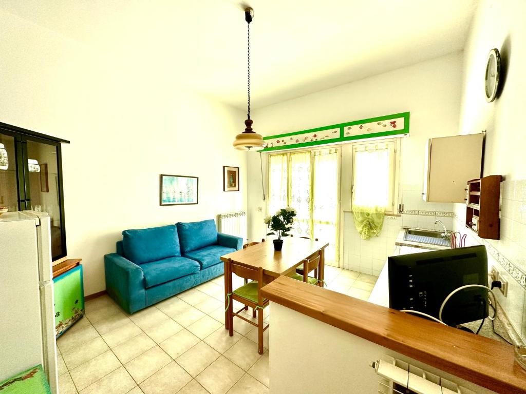 sala de estar con sofá azul y mesa en Appartamento Mareadi, en Marina di Grosseto